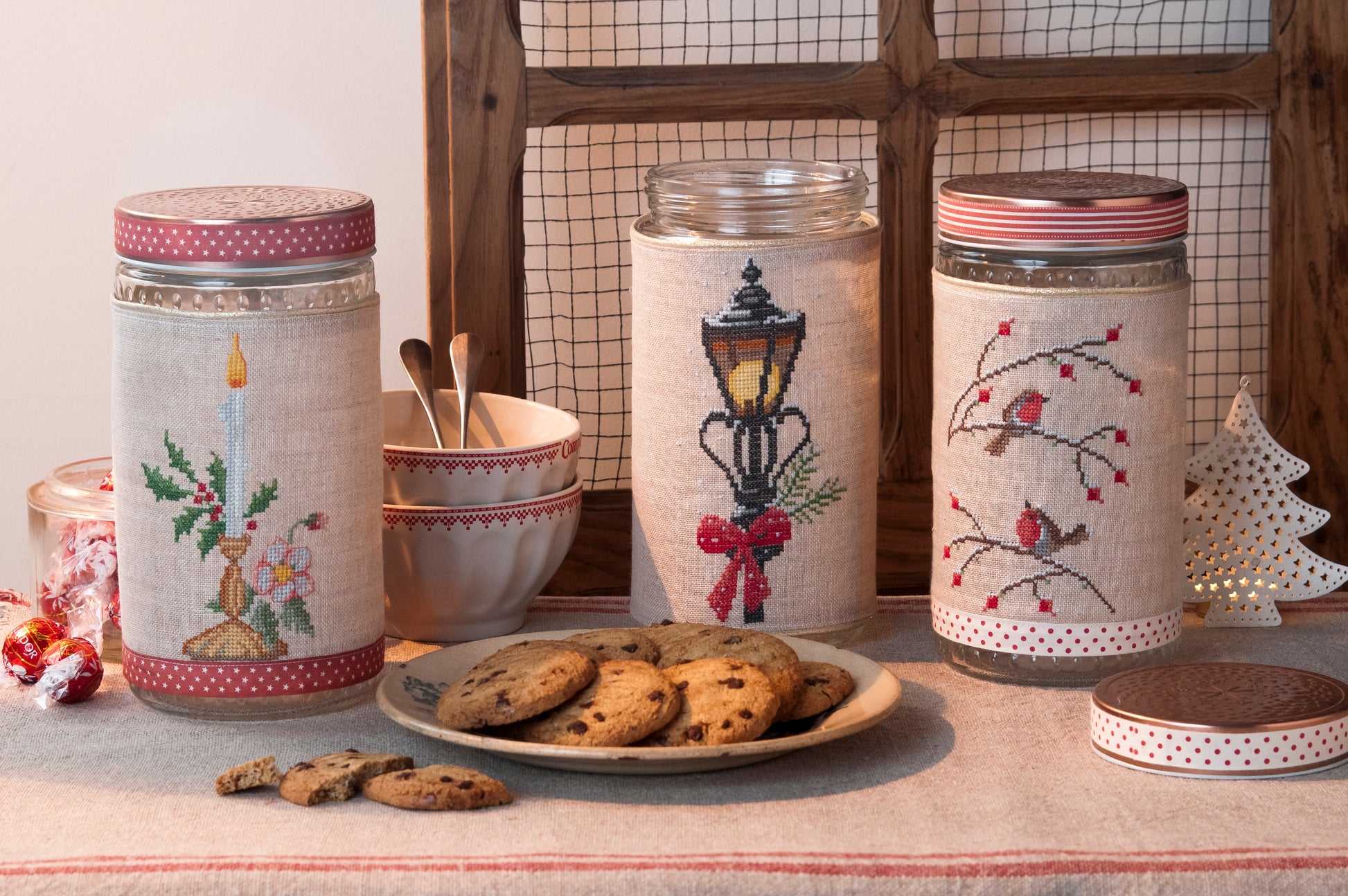 Grille de broderie point de croix : biscuits de Noël sur pots en verre (bougie, branche, réverbère). Imprimé couleur (Réf. DMC) sur 6 pages.