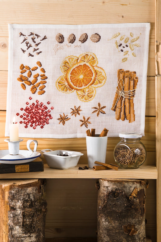 Grille de broderie point de croix « Chaleur des épices » par Création Point de Croix. Composition hivernale aux motifs de badiane, cannelle, cacao et orange séchée. À broder sur lin ou Aïda.