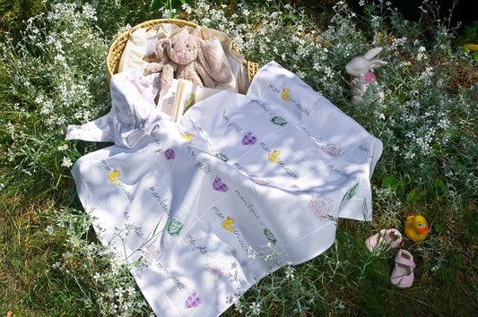 Grille broderie point de croix : plaid bébé avec frises chou, rose, cœur et canard. Motifs sur laid bébé blanc. Sur Aïda 5,5 pts ou lin 11 fils. Ref. DMC.