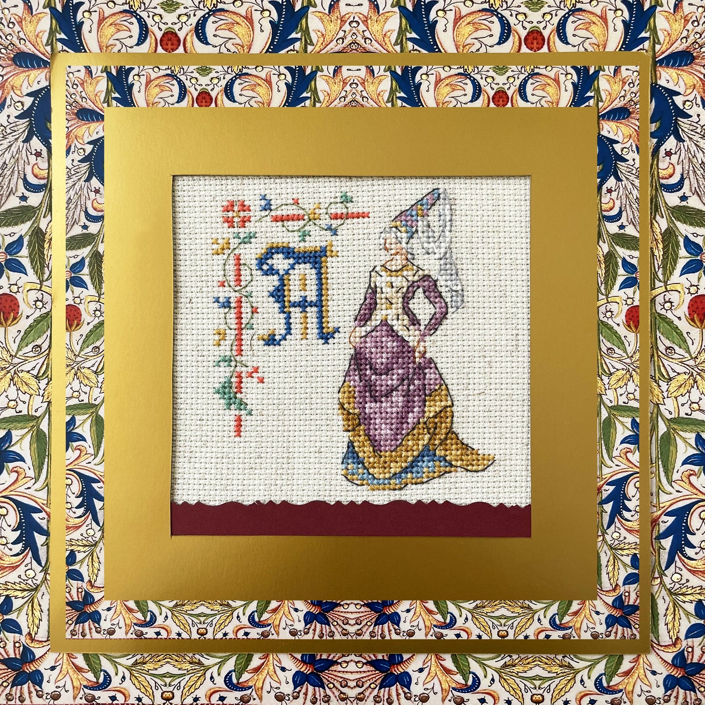 Grille point de croix : alphabet médiéval, damoiselles et motifs floraux. 52×52 pts, lin 11 fils/cm ou Aïda 5,5 pts/cm. 6 pages couleur, réf. DMC.