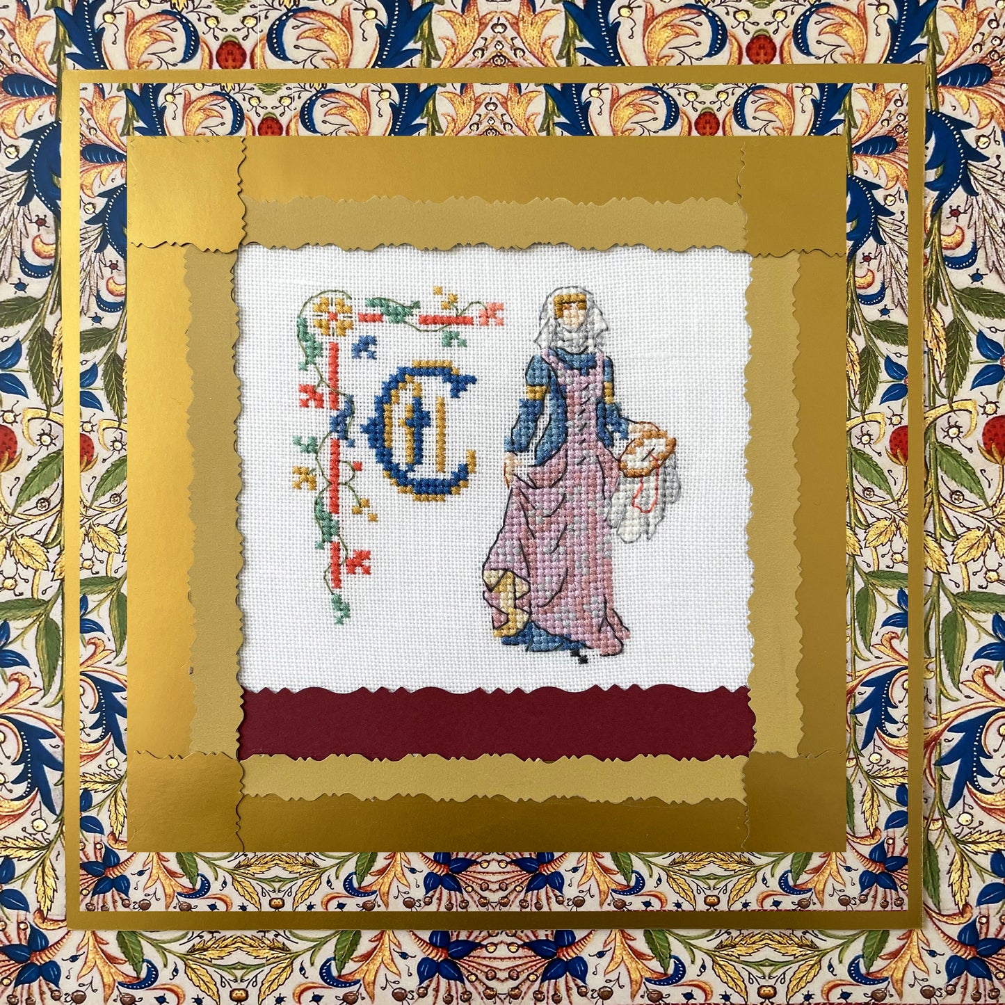 Grille point de croix : alphabet médiéval, damoiselles et motifs floraux. 52×52 pts, lin 11 fils/cm ou Aïda 5,5 pts/cm. 6 pages couleur, réf. DMC.