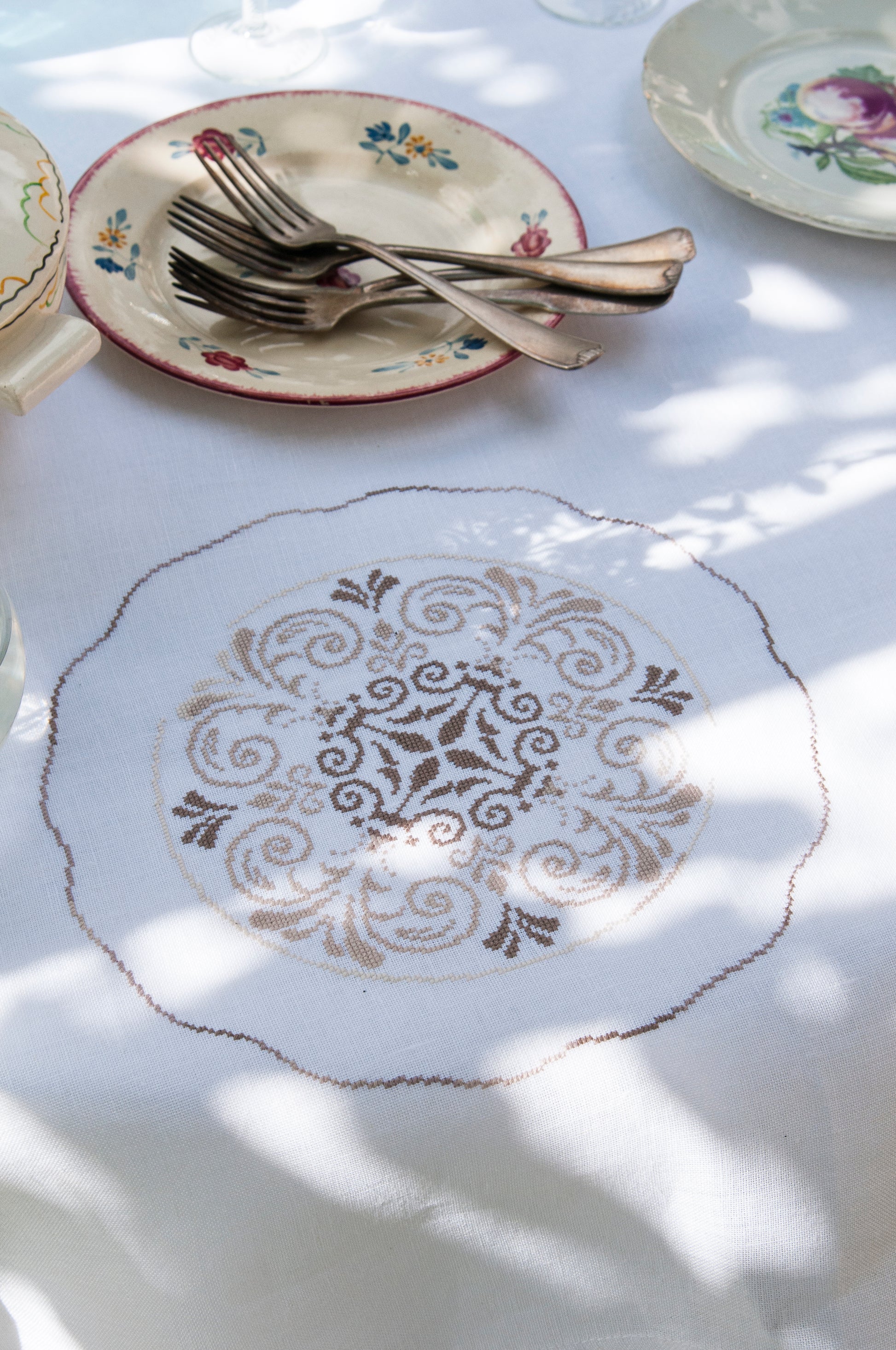 Grille point de croix : collection d'assiettes anciennes brodées sur nappe blanche. Motif 818 x 816 points (148,72 x 148,36 cm), 12 pages, DMC.