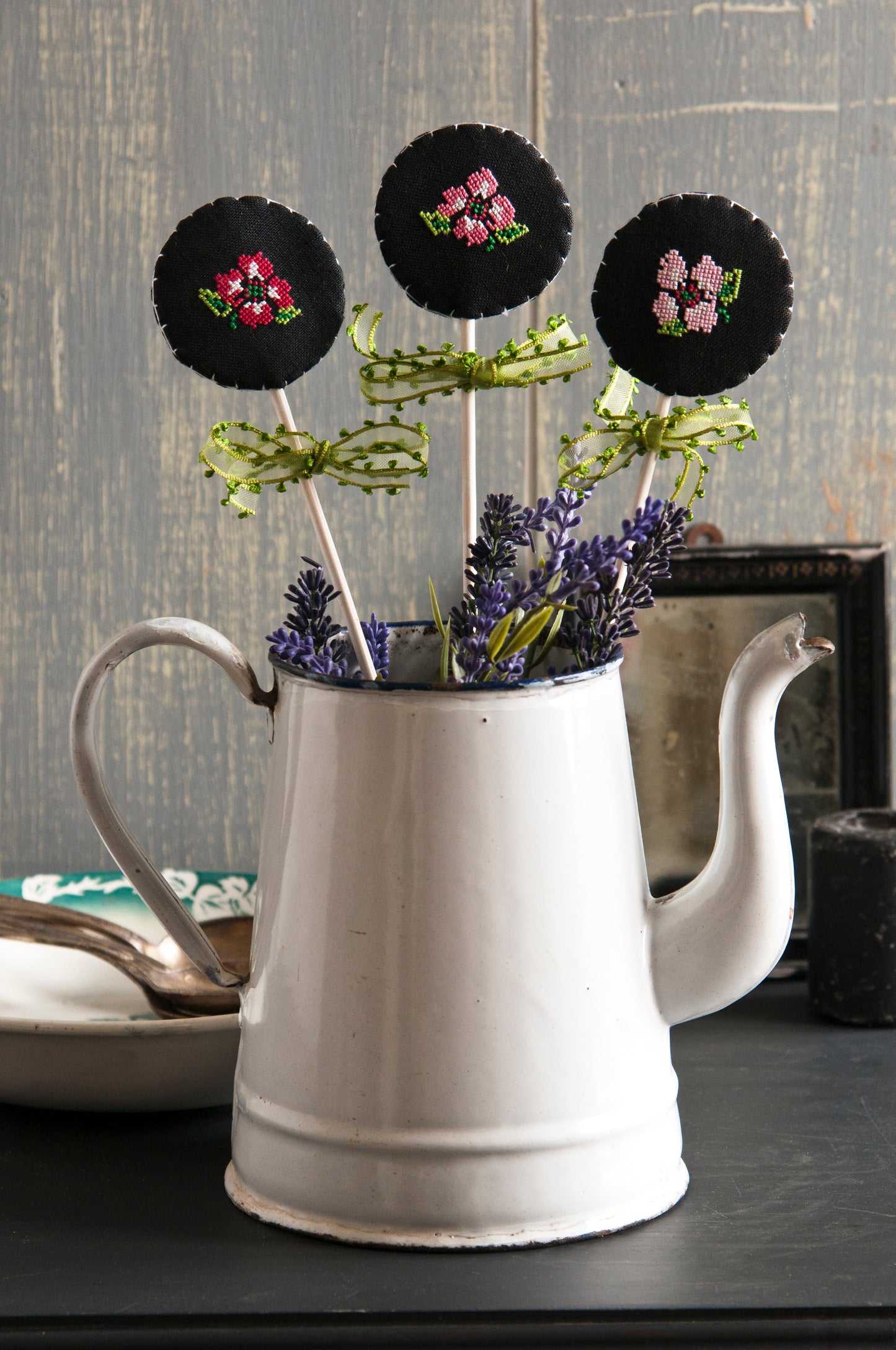 Grille point de croix : 3 petites fleurs brodées pour pots fleuris. Imprimée sur 4 pages avec symboles et couleurs DMC. Lin 16 fils noir.