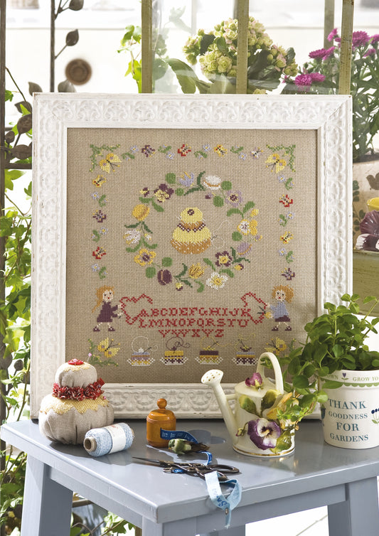 Grille de point de croix Douceurs du Jardin – poussin entouré de fleurs printanières et alphabet brodé, brodé sur lin DMC 11 fils/cm, Création Point de Croix