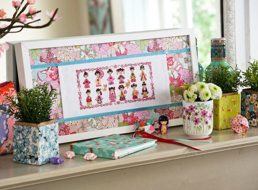 Grille de point de croix 12 kokeshi japonaises pour tableau. Sur Aïda 7 pts blanc DMC. Imprimée avec symboles et couleur DMC sur 6 pages. Motif 75 x 165 pts.