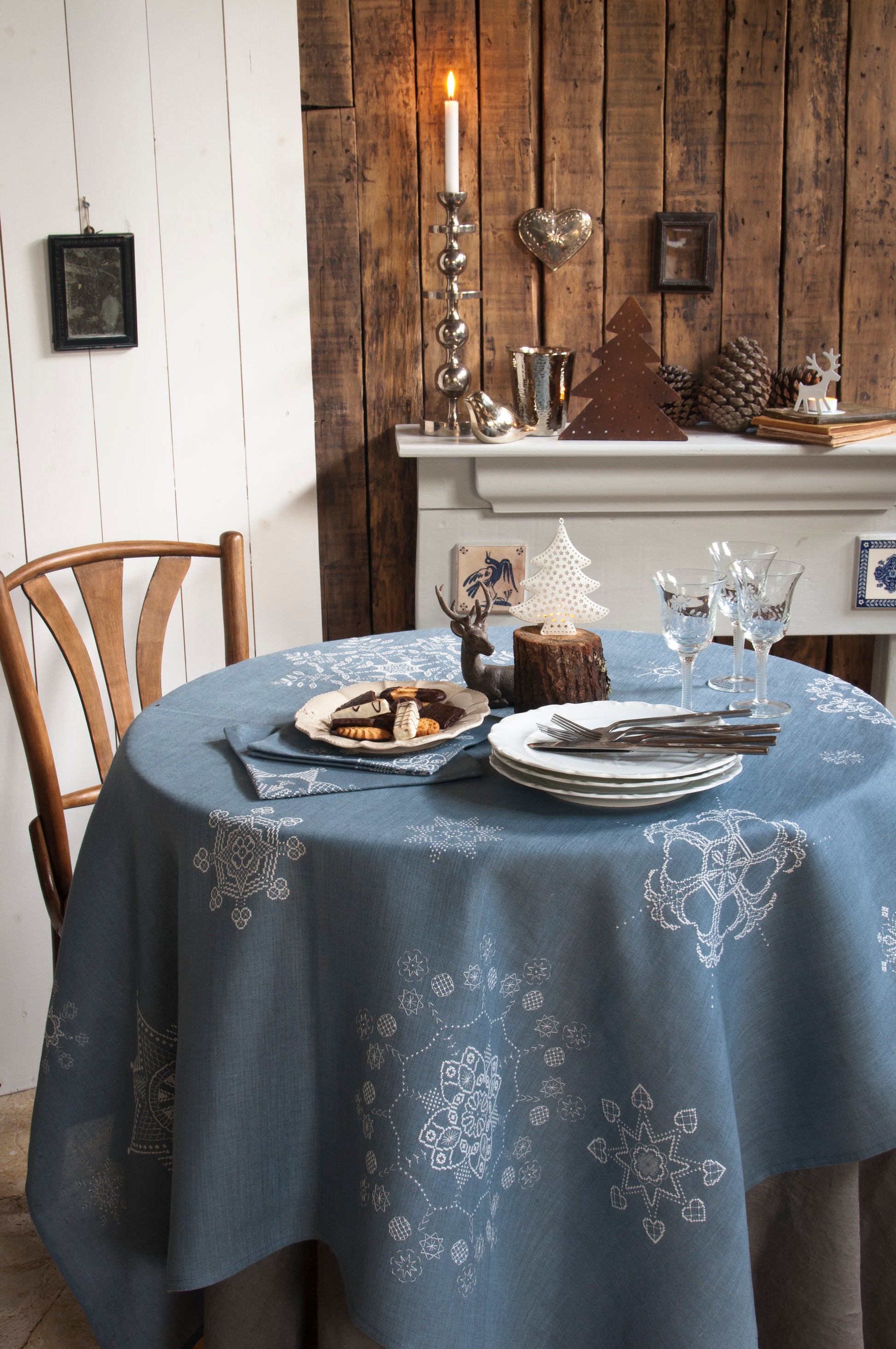Grille de broderie point de croix « Flocons de Noël » : nappe et serviettes brodées de flocons sur toile de lin bleue. DMC, 10 pages – déco de table Noël.