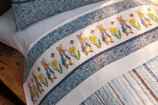 Grille point de croix : frise Pierrot-Lapin pour drap sur lin DMC. Motif 150 × 24 pts, env. 27,3 × 4,4 cm. Imprimé symboles & couleurs, 6 pages.
