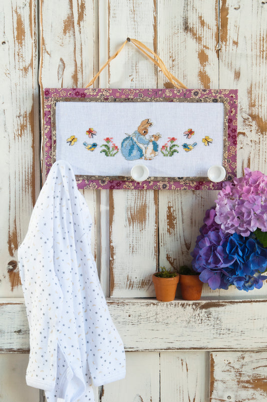 Grille point de croix : frise porte-manteaux Pierrot-Lapin sur lin blanc DMC. Motif 114 × 34 pts, env. 20,7 × 6,2 cm. Imprimé symboles & couleurs, 6 pages.