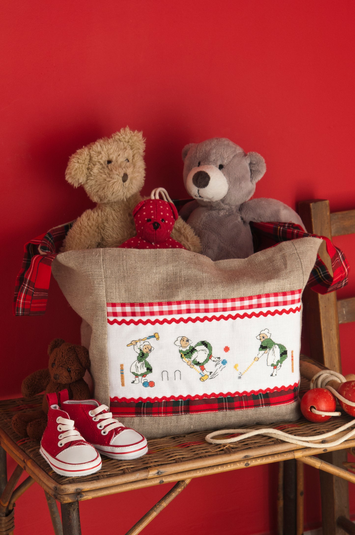 Grille broderie point de croix : sac rangement jouets Bécassine, motif 128×38 pts, 23,3×6,9 cm. Symboles + couleurs DMC, 6 pages.