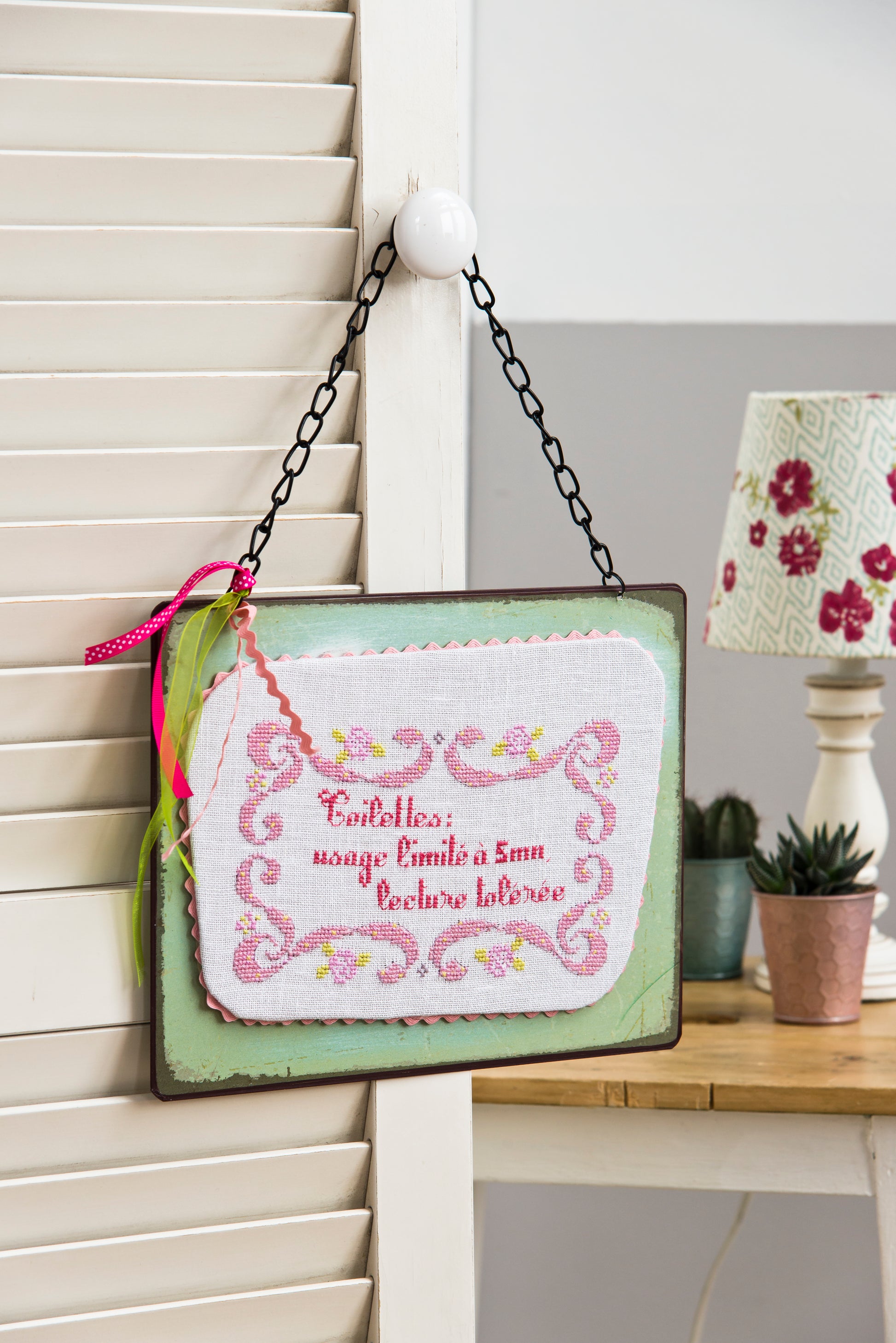Une grille point de croix humoristique et élégante pour décorer les toilettes avec style. Arabesques, message décalé et coloris vintage signés P. Samouiloff.