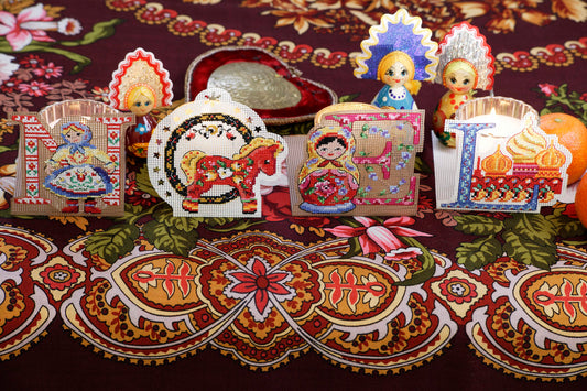Grille de point de croix lumignons Noël sur carton perforé. Lettres brodées en photophores. Imprimée avec symboles et couleur DMC sur 6 pages. Motif 52 x 52 pts.