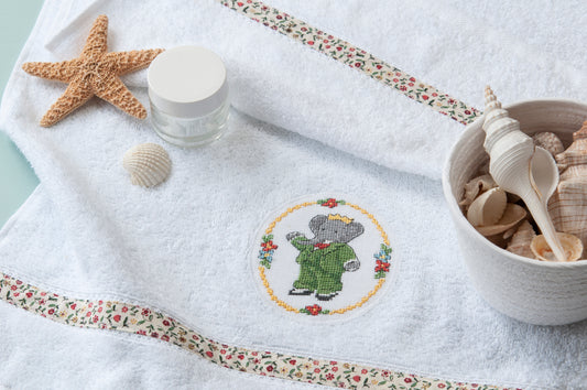 Grille broderie point de croix : médaillon Babar pour serviette de bain, motif 49×59 pts, 9×11 cm. Symboles + couleurs DMC, 6 pages.