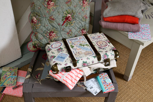 Grille de point de croix Ma petite valise parisienne avec abécédaire : valise et étiquettes sur Aïda 5,5 écru. Références DMC sur 6 pages.