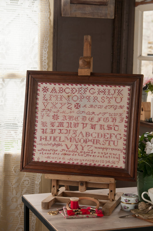 Grille de broderie point de croix « Marquoir Léontine » : reproduction d'un marquoir de 1868 sur toile bis 12 fils. DMC, 8 pages, motif 34,9 x 34,9 cm.