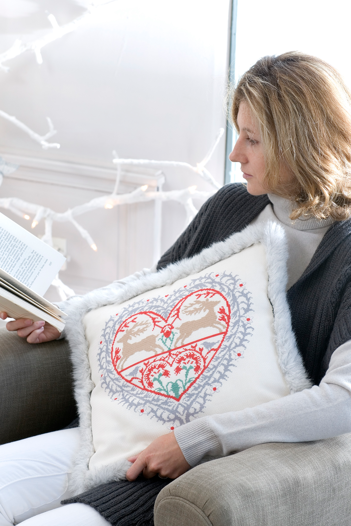 Grille broderie point de croix : coussin montagne sur Aïda lin 5,5 pts écru. 2 motifs robes, réf. DMC incluses. Ambiance cosy et hivernale.