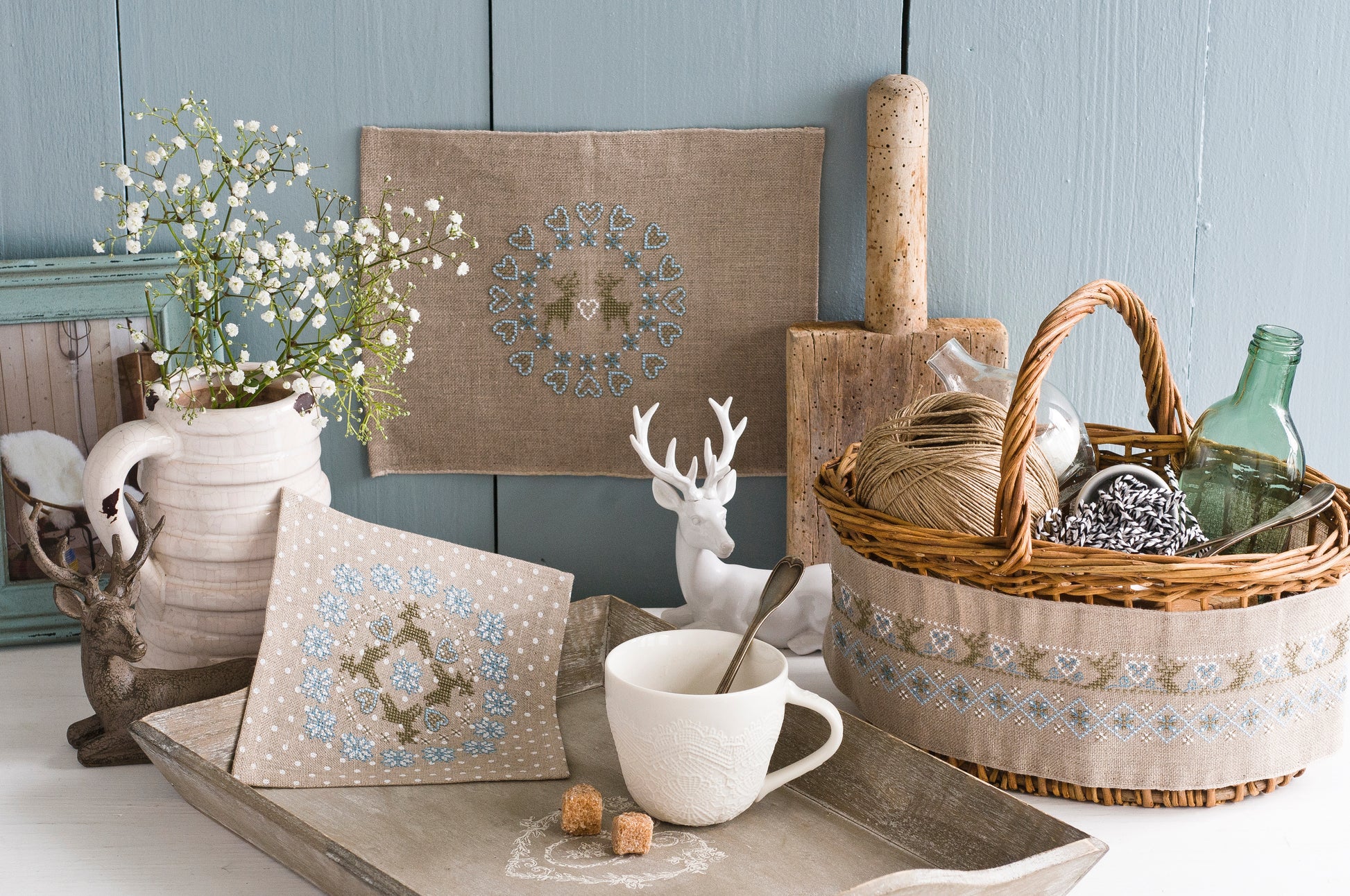 Frises et motifs géométriques nordiques brodés sur lin naturel ou gris perlé, signés M.A. Réthoret-Melin. Cœurs, cerfs et motifs folkloriques en bleu et brun.