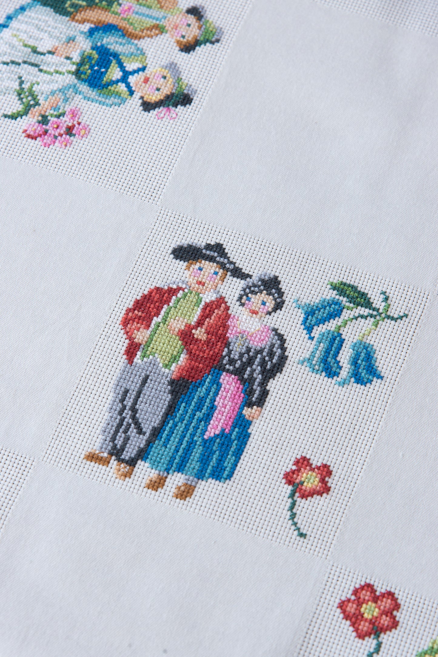 Grille de broderie point de croix « Nappe Tyrol » par M. Bonnin : personnages en costume tyrolien sur Aïda blanc 5,5 pts. DMC, 6 pages, motif 12,36 x 12,36 cm.