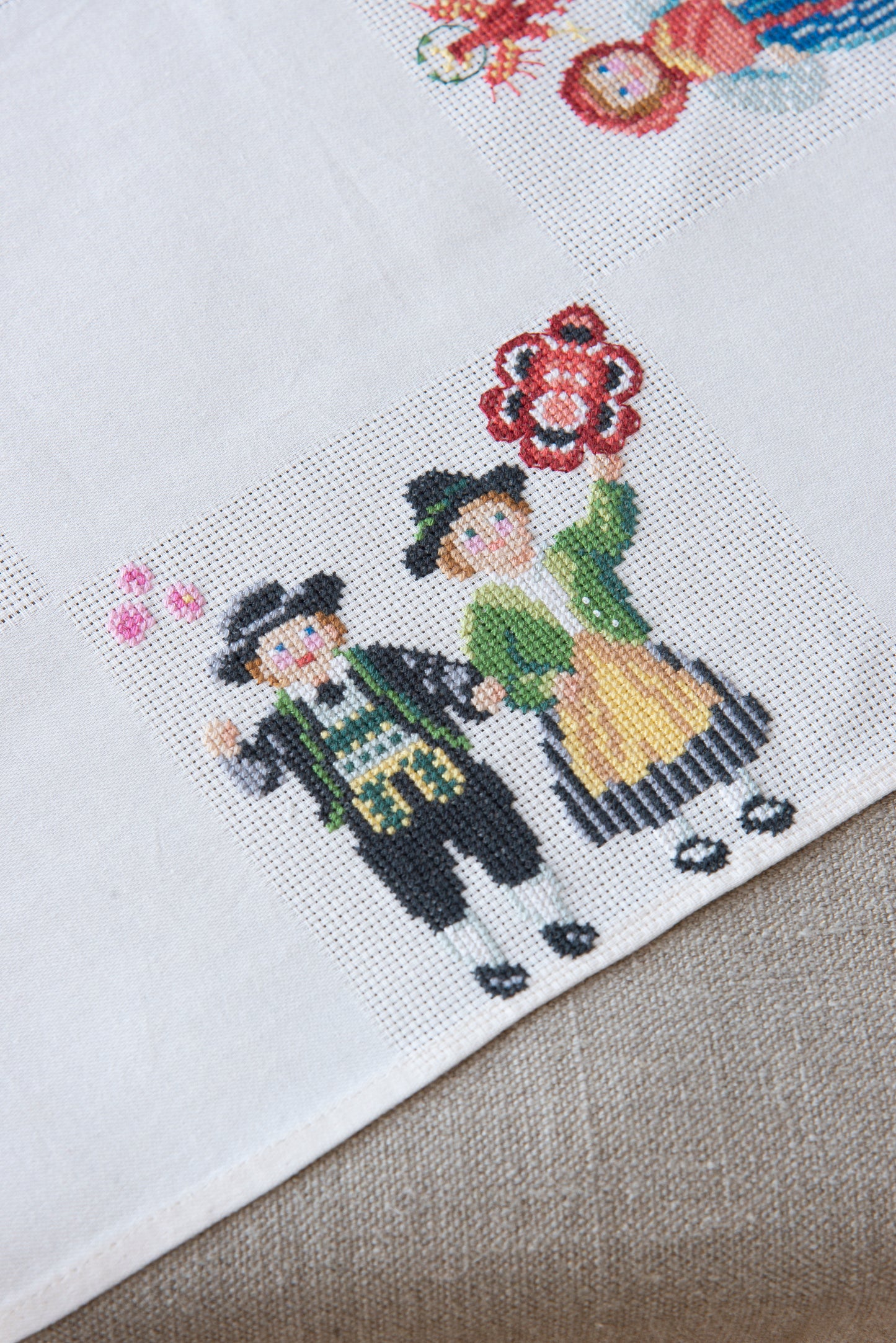 Grille de broderie point de croix « Nappe Tyrol » par M. Bonnin : personnages en costume tyrolien sur Aïda blanc 5,5 pts. DMC, 6 pages, motif 12,36 x 12,36 cm.