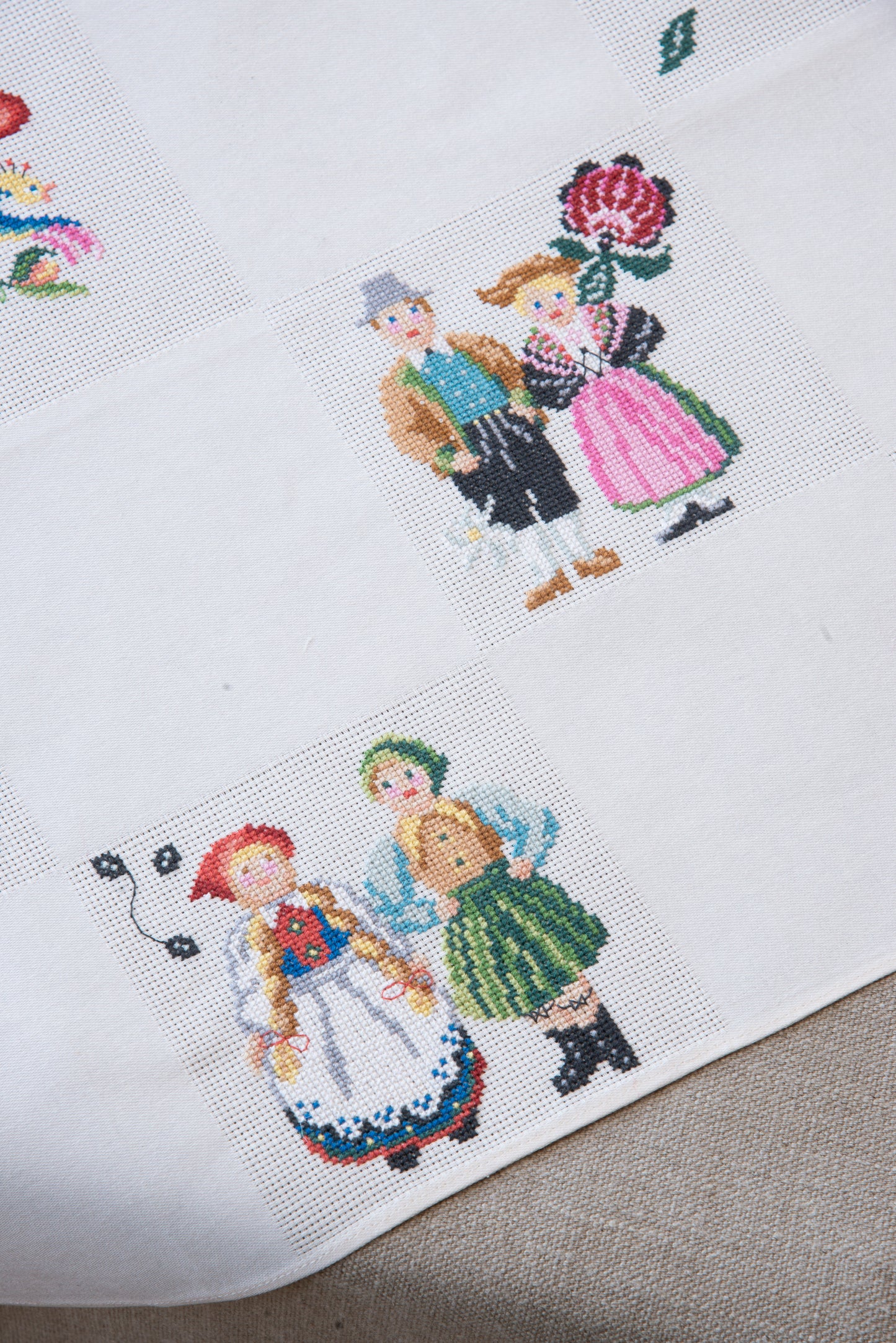 Grille de broderie point de croix « Nappe Tyrol » par M. Bonnin : personnages en costume tyrolien sur Aïda blanc 5,5 pts. DMC, 6 pages, motif 12,36 x 12,36 cm.