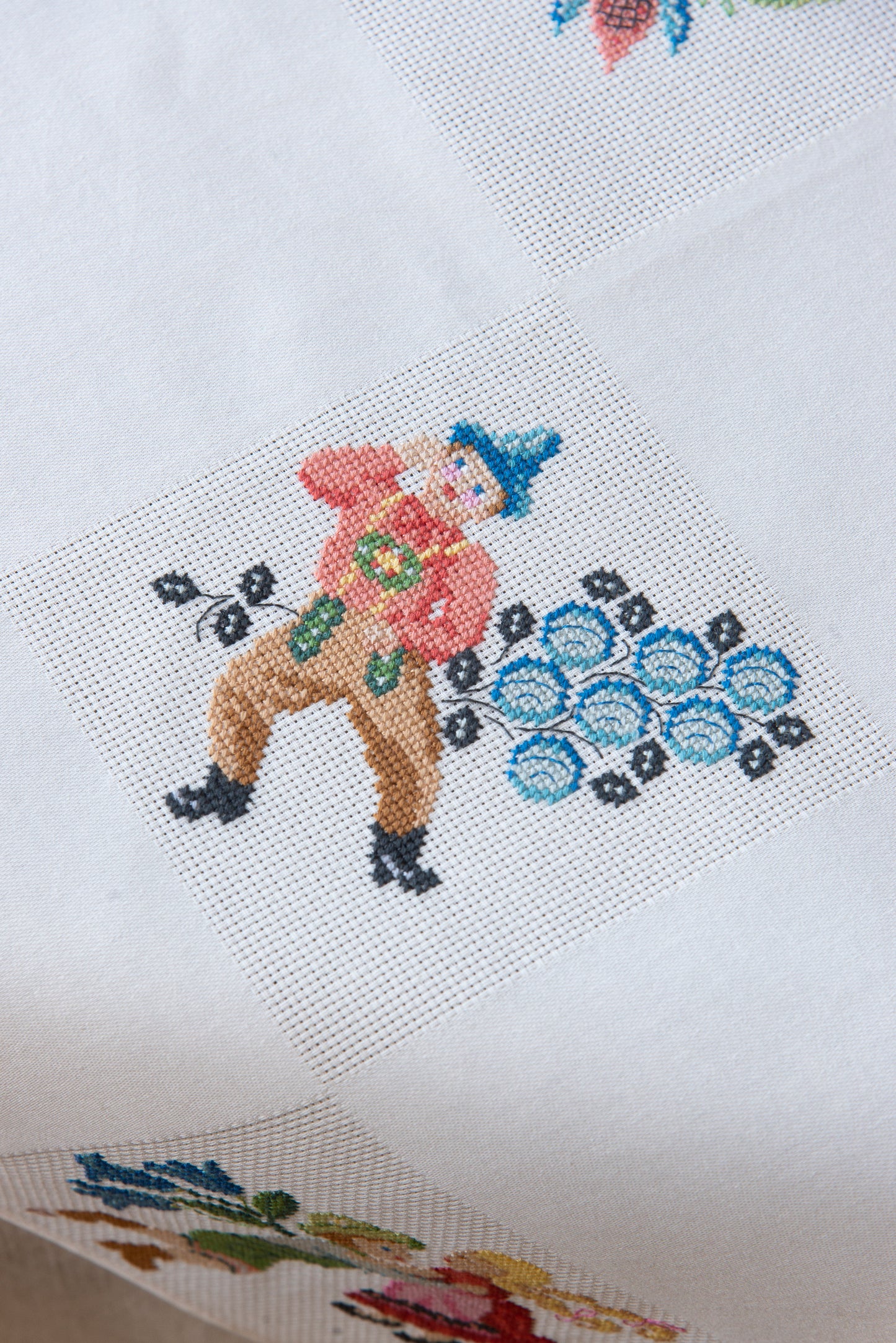 Grille de broderie point de croix « Nappe Tyrol » par M. Bonnin : personnages en costume tyrolien sur Aïda blanc 5,5 pts. DMC, 6 pages, motif 12,36 x 12,36 cm.