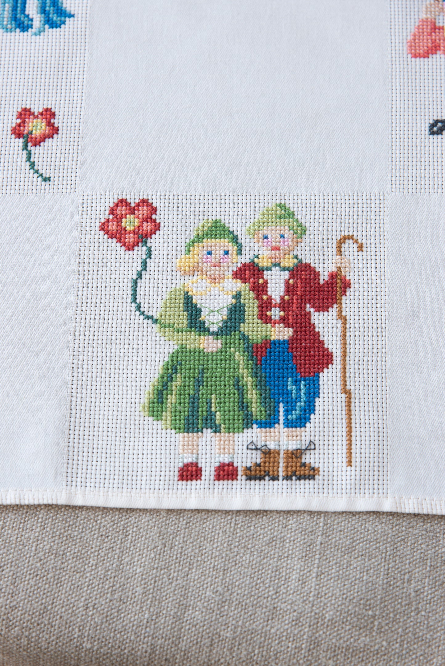 Grille de broderie point de croix « Nappe Tyrol » par M. Bonnin : personnages en costume tyrolien sur Aïda blanc 5,5 pts. DMC, 6 pages, motif 12,36 x 12,36 cm.