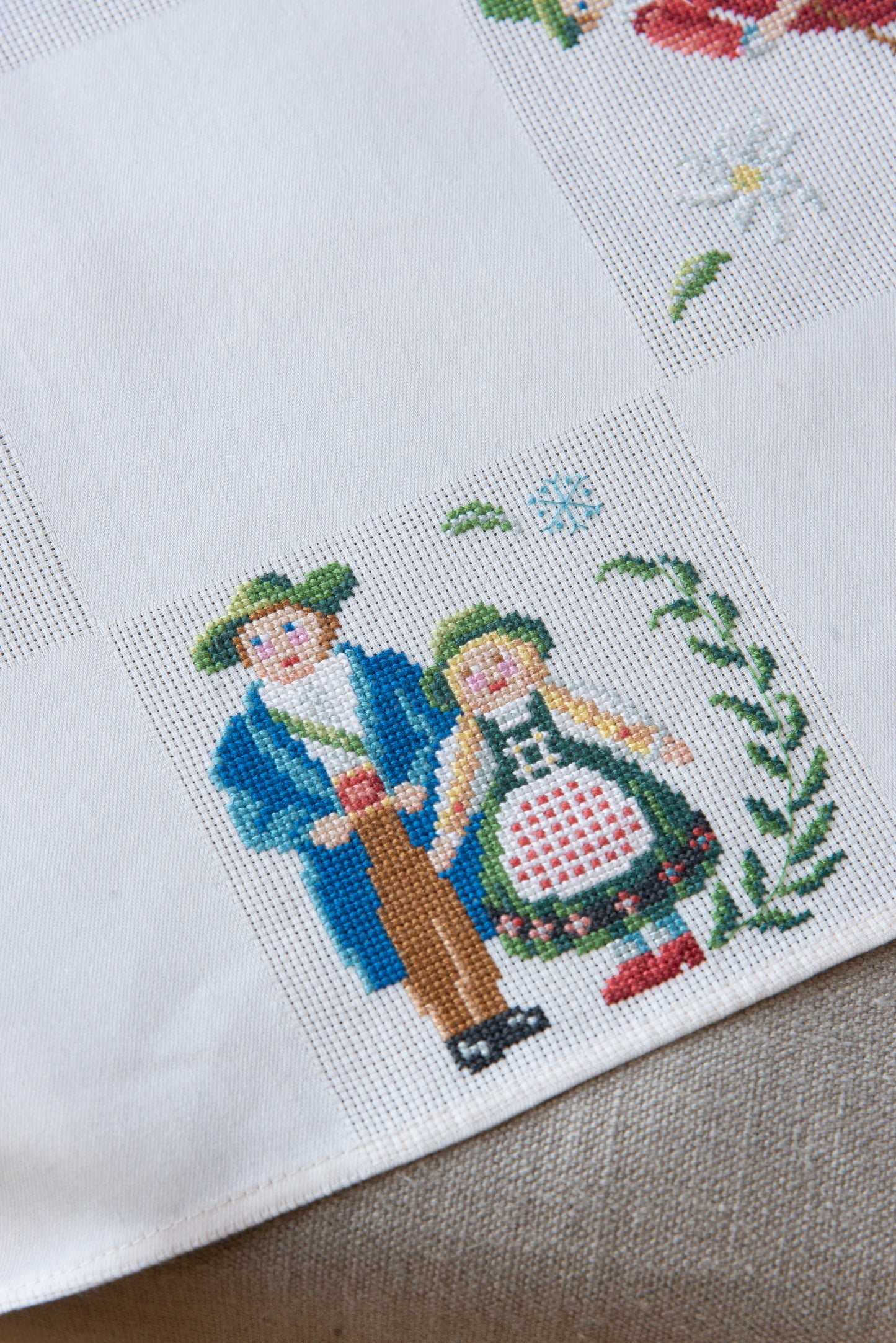 Grille de broderie point de croix « Nappe Tyrol » par M. Bonnin : personnages en costume tyrolien sur Aïda blanc 5,5 pts. DMC, 6 pages, motif 12,36 x 12,36 cm.