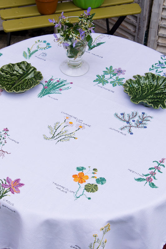 Grille de broderie point de croix : nappe herbier, motifs botaniques par M. Bonnin. Réf. DMC incluse. À broder sur nappe damassée ou lin. Création Point de Croix.