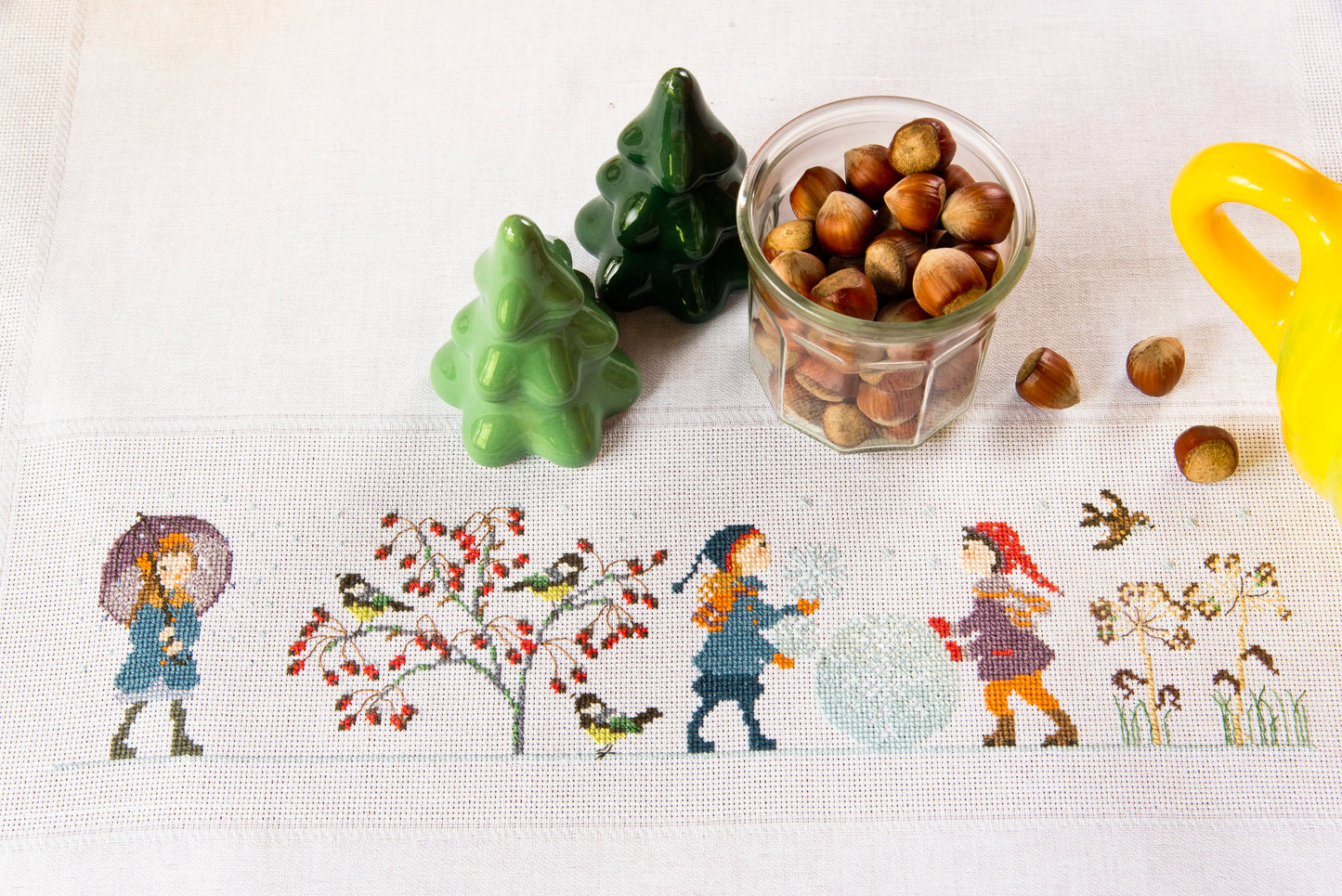 Grille de broderie point de croix : nappe hiver avec scènes enneigées par P. Samouiloff. Réf. DMC incluse. À broder sur Aïda ou lin. Création Point de Croix.