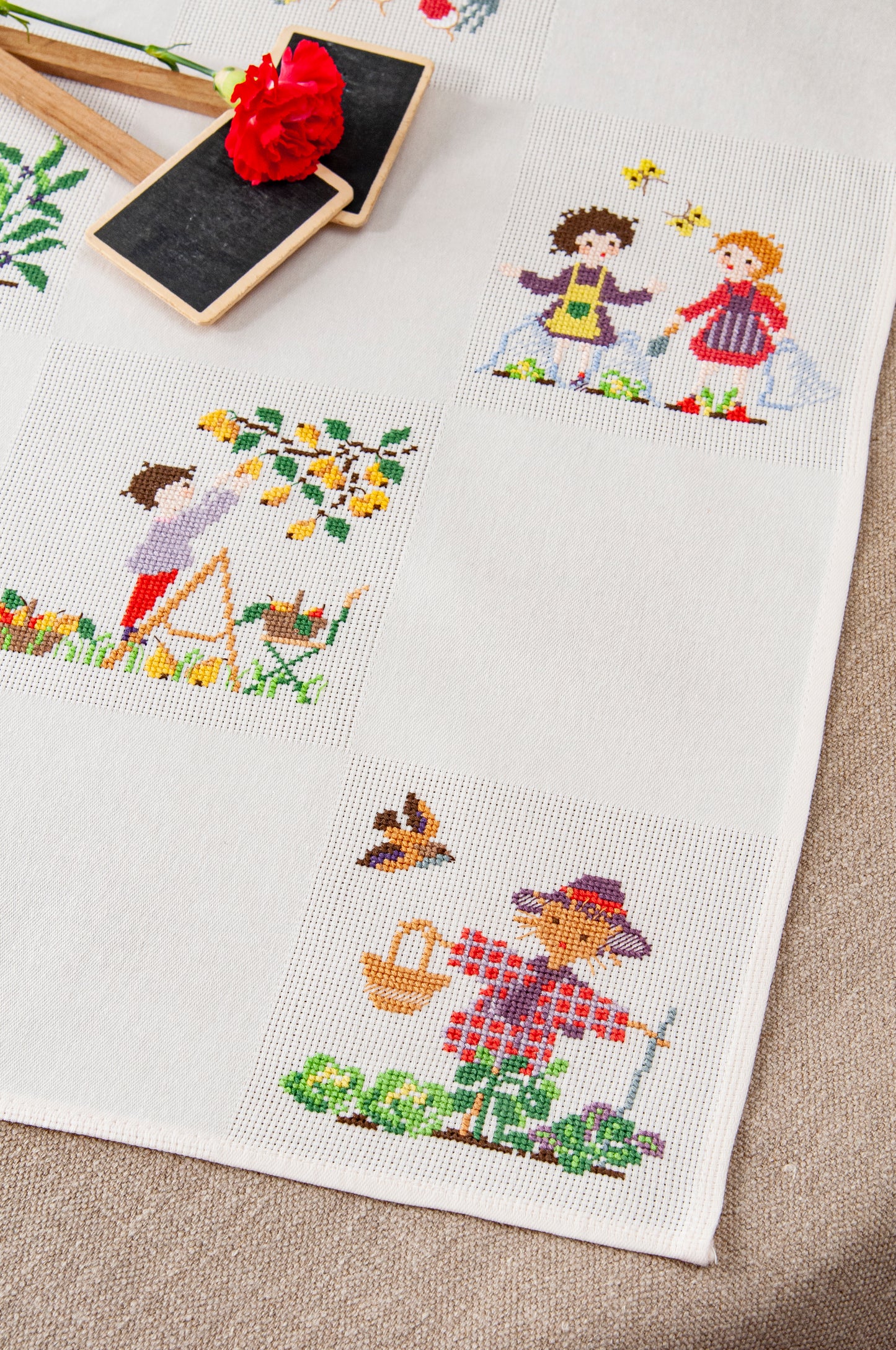 Grille de broderie point de croix « Nappe potager » par P. Samouiloff : personnages du potager à broder sur Aïda blanc 5,5 pts. DMC, 10 pages – ambiance champêtre.