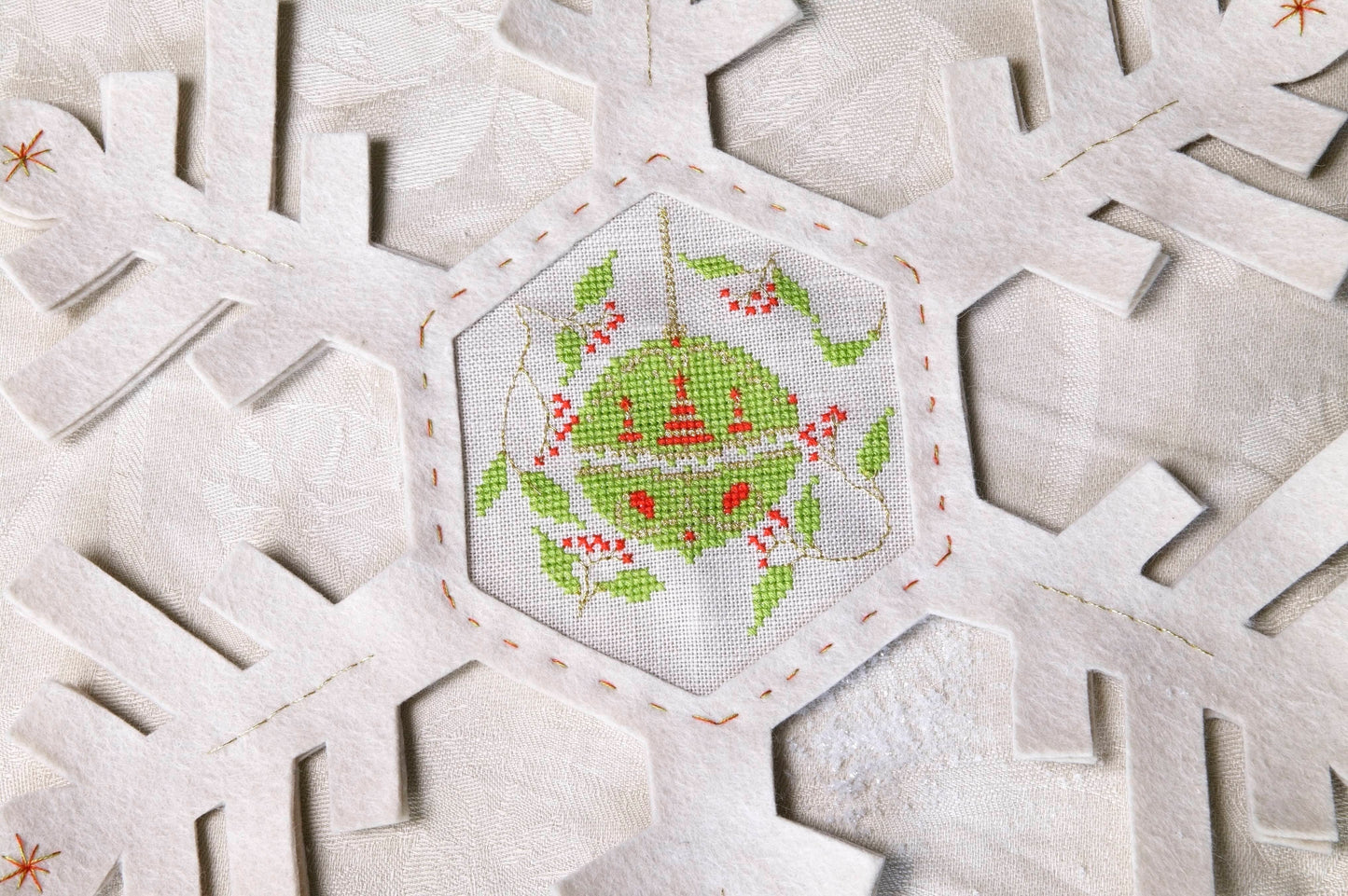 Grille de broderie point de croix : napperon de neige, motifs boule de Noël et sapin sur 4 pages. Symboles et couleurs DMC, sur lin blanc.