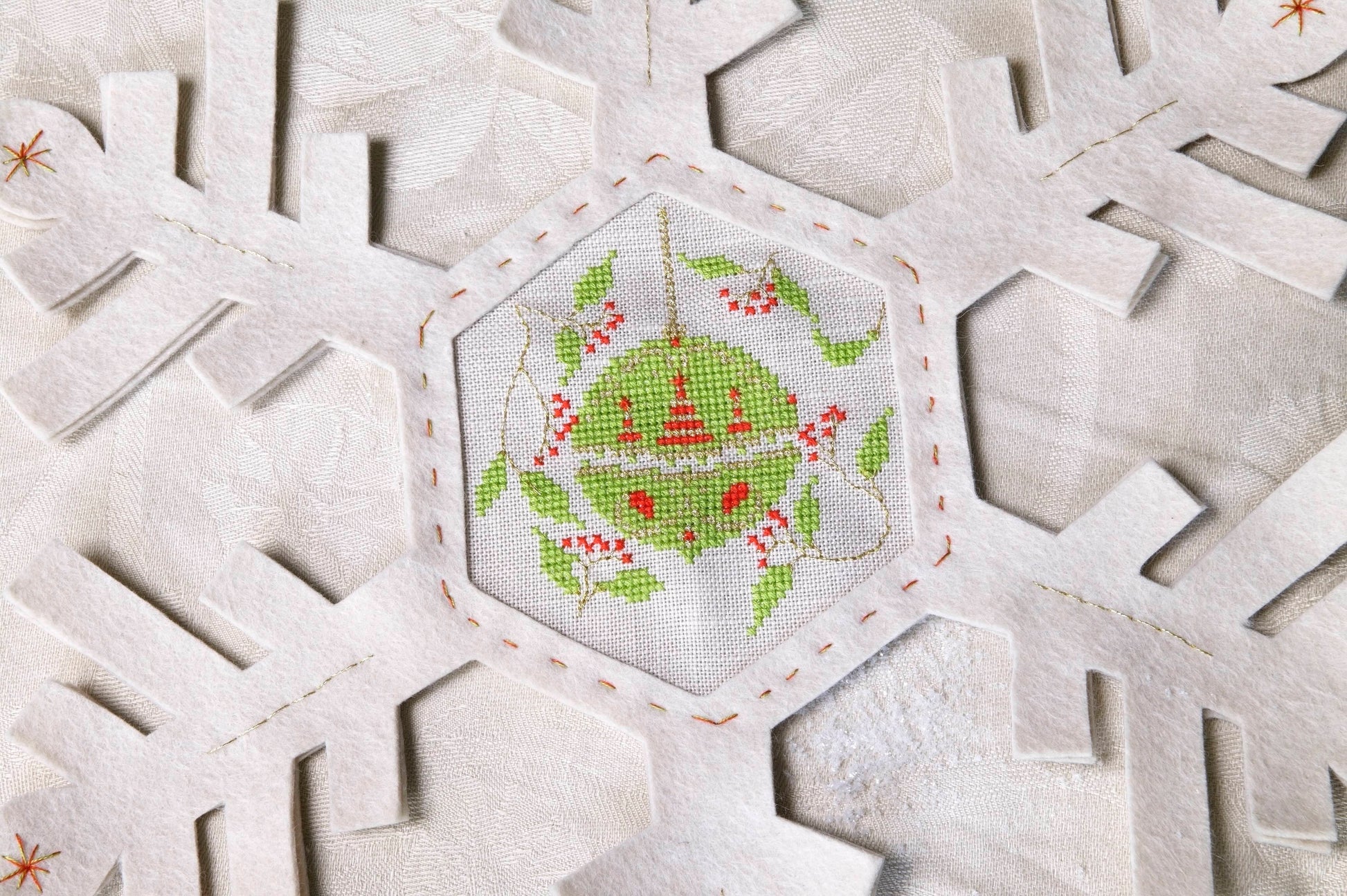 Grille de broderie point de croix : napperon de neige, motifs boule de Noël et sapin sur 4 pages. Symboles et couleurs DMC, sur lin blanc.