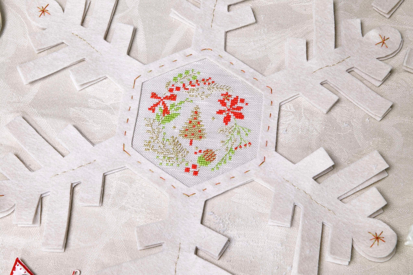 Grille de broderie point de croix : napperon de neige, motifs boule de Noël et sapin sur 4 pages. Symboles et couleurs DMC, sur lin blanc.