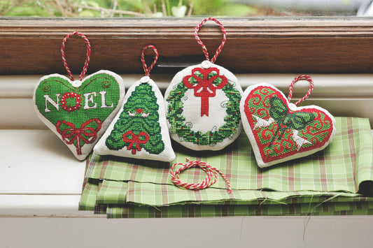 Grille broderie point de croix : ornements de Noël (cœurs, sapin, couronne). Environ 8-10 cm par motif, imprimée en couleur sur 4 pages. Réf. DMC incluses.