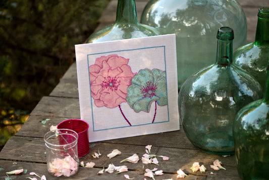 Grille point de croix – Petites fleurs roses & bleues : vue détail des motifs floraux roses et bleus sur toile de lin blanc DMC – Création Point de Croix