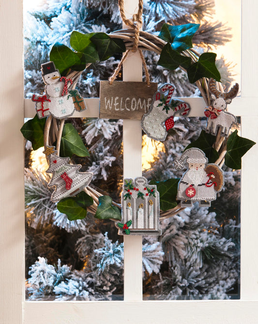 Grille de broderie point de croix : petits ouvrages de Noël, couronne, guirlande et carte brodée sur 8 pages. Symboles et couleurs DMC.