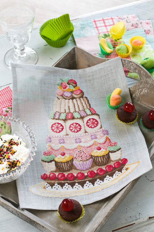 Grille de broderie point de croix « Pièce montée » par Création Point de Croix. Composition gourmande aux motifs de cupcakes, macarons et choux à la crème. À broder sur lin ou Aïda.