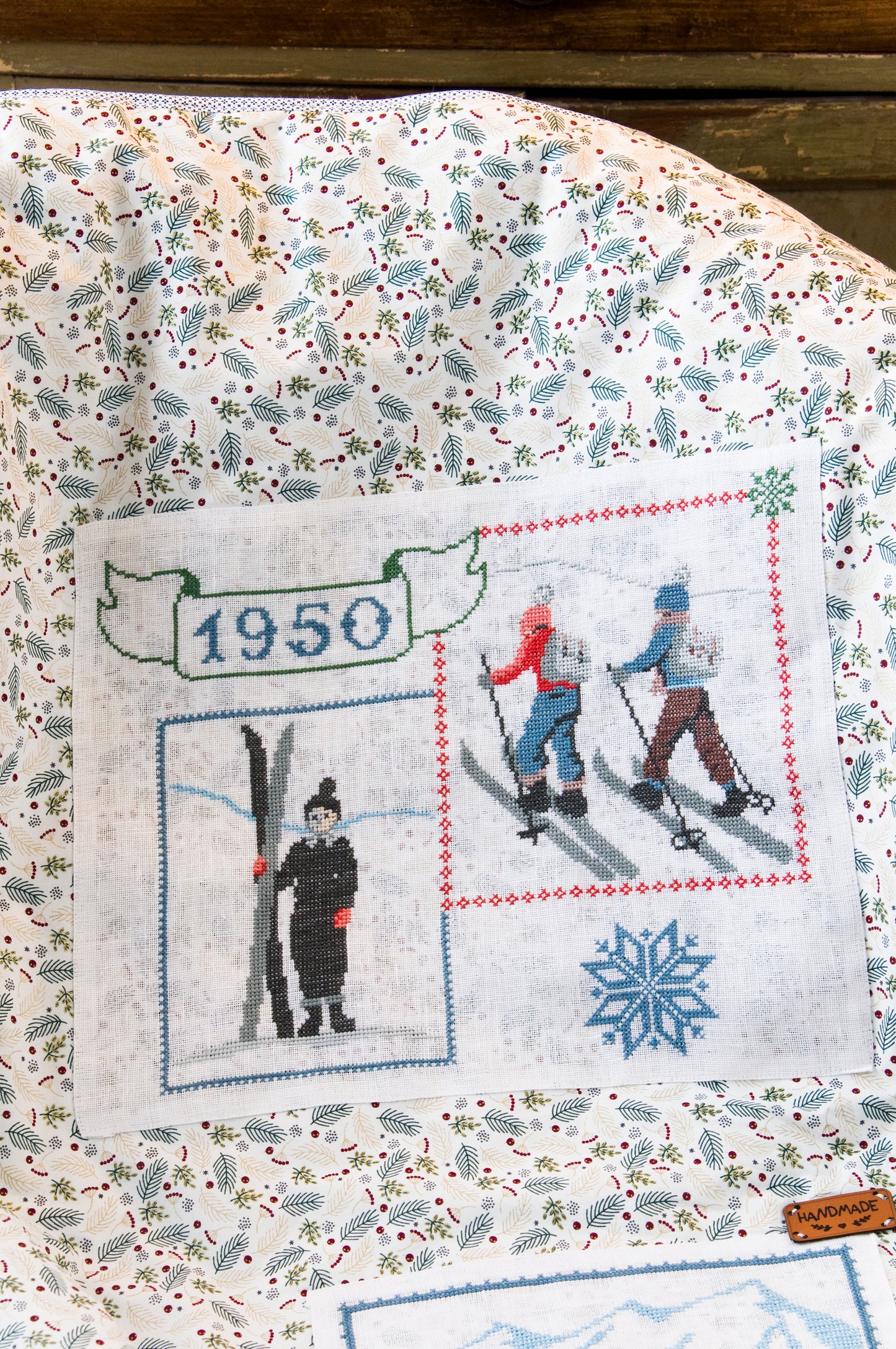 Grille de broderie point de croix : plaid skieurs années 30, silhouettes élégantes sur fond patchwork pastel. Imprimé couleur (Réf. DMC) sur 10 pages. Illustration Sylvie Teytaud.