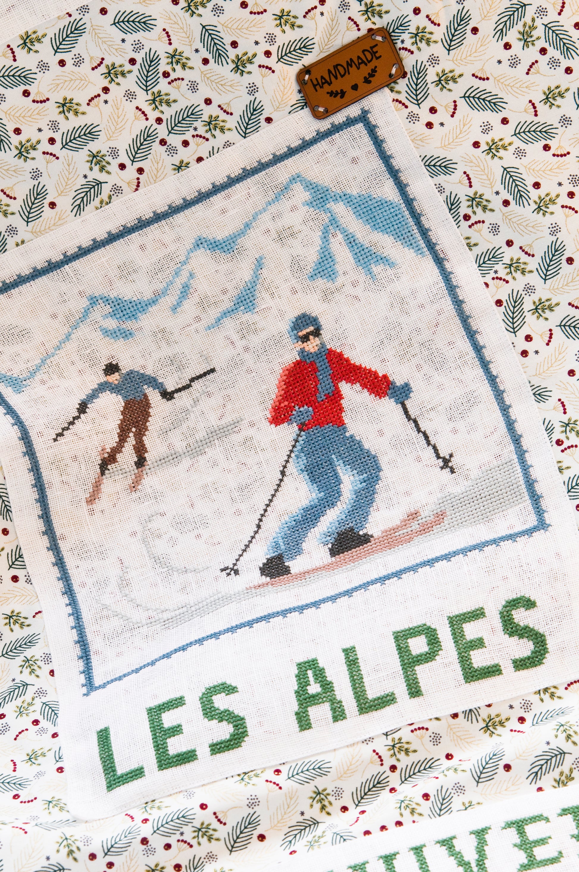 Grille de broderie point de croix : plaid skieurs années 30, silhouettes élégantes sur fond patchwork pastel. Imprimé couleur (Réf. DMC) sur 10 pages. Illustration Sylvie Teytaud.