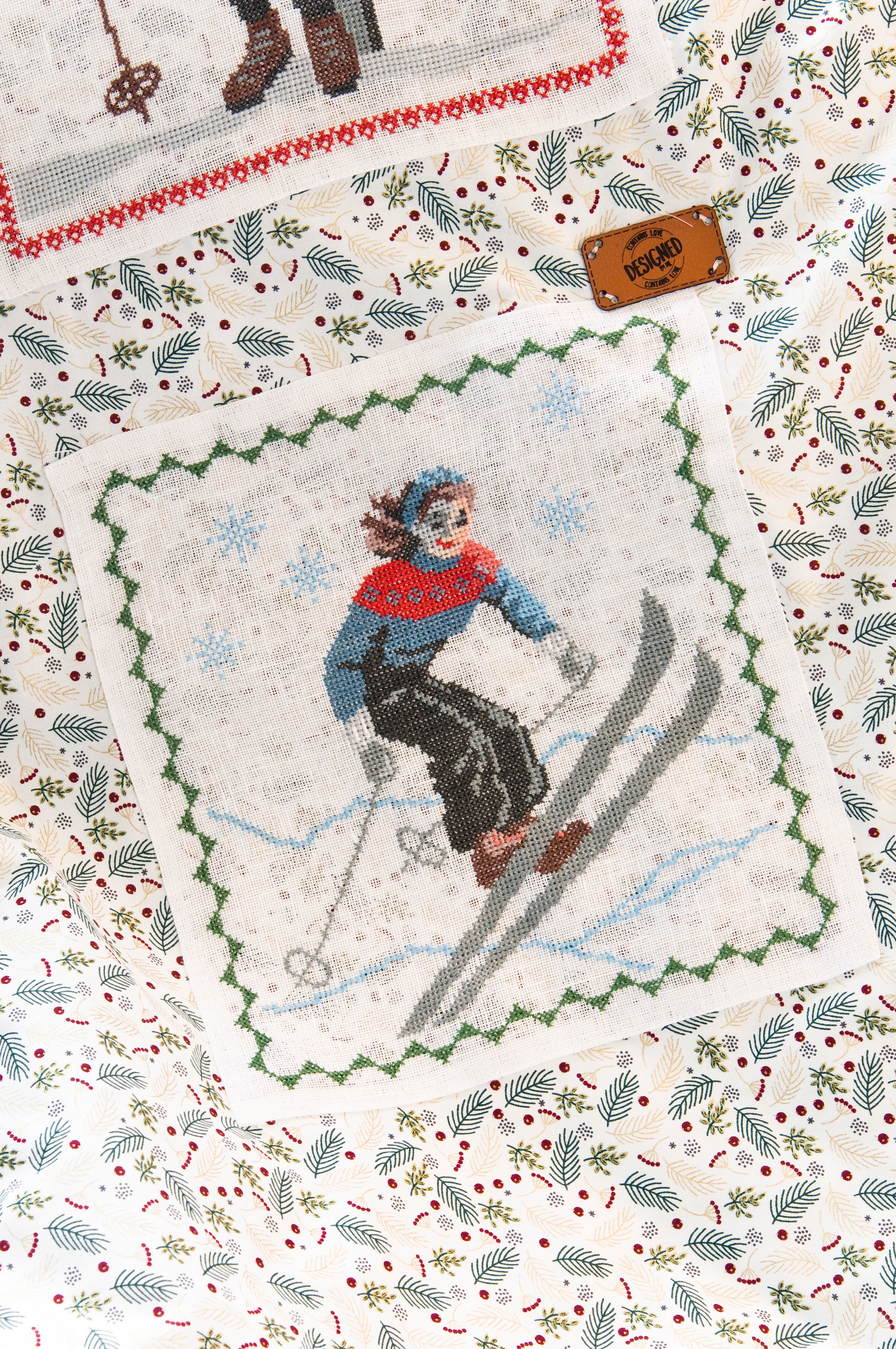 Grille de broderie point de croix : plaid skieurs années 30, silhouettes élégantes sur fond patchwork pastel. Imprimé couleur (Réf. DMC) sur 10 pages. Illustration Sylvie Teytaud.