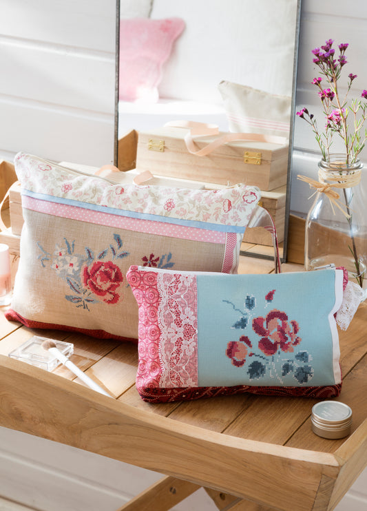 Grille point de croix : pochette et trousse de toilette brodées de roses. Imprimée sur 6 pages avec symboles et couleurs DMC. Lin 12 fils naturel.