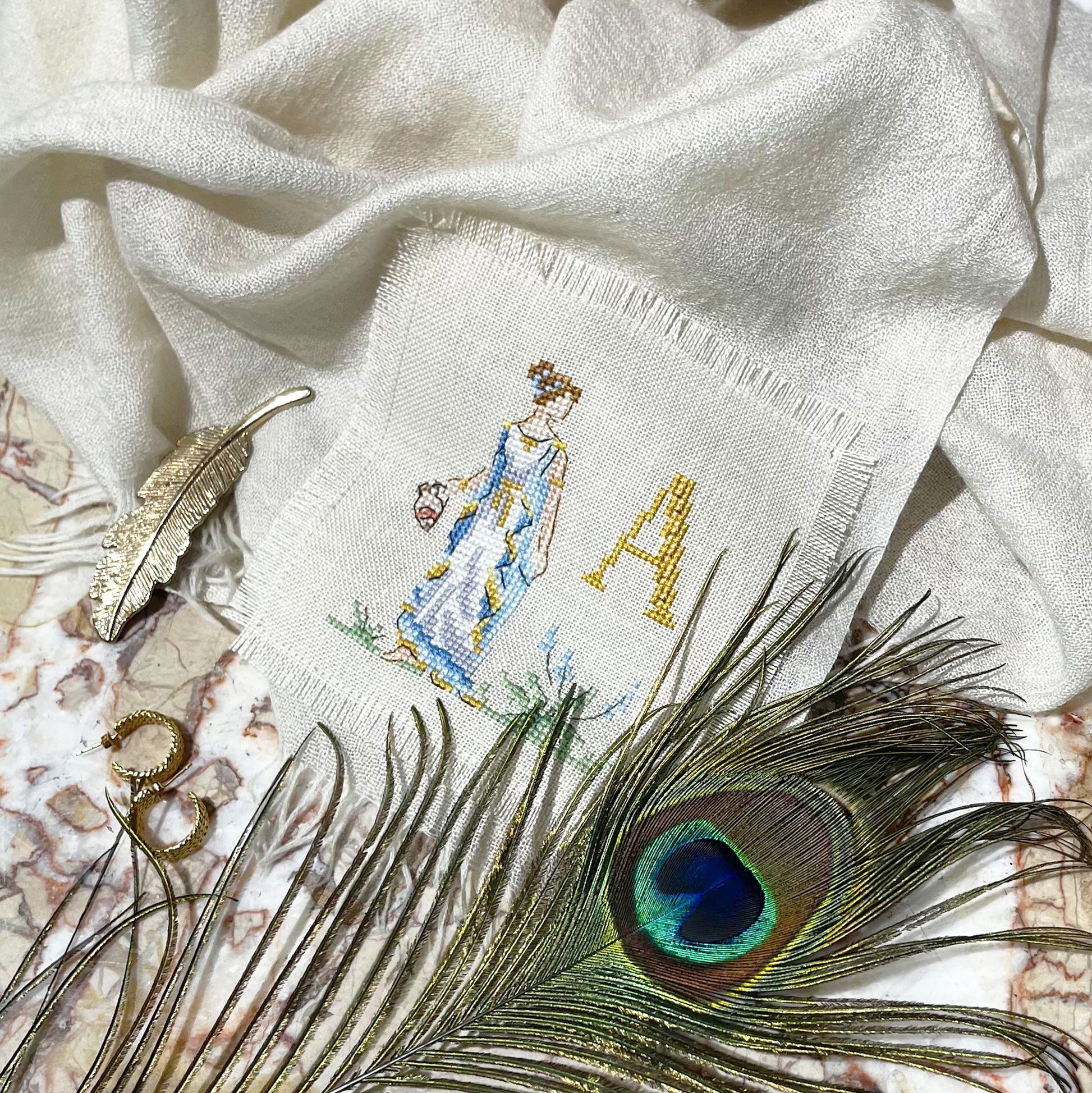 Grille inédite broderie point de croix : Sous le regard des déesses. Pénélope, Ulysse et l'alphabet en couleurs douces. Toile Aïda 5,5 pts/cm ou lin 11 fils/cm. Réf. DMC, 6 pages.