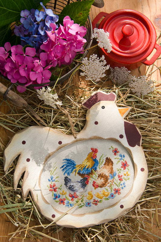 Grille point de croix : poules et coq dans un jardin fleuri. Sur lin 7 pts beige, motif 95x65 pts, environ 11,8x17,3 cm. 6 pages DMC. Décor campagnard.