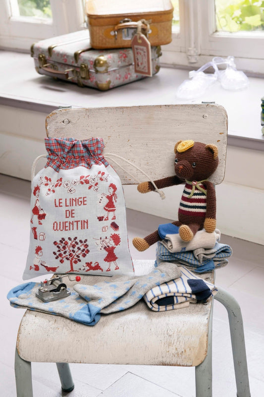 Grille broderie point de croix : pochon pour petit linge d'enfant. 90 x 89 pts, imprimée en couleur sur 4 pages. Réf. DMC incluses.