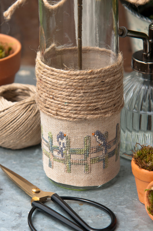 Grille de broderie point de croix « Printemps au jardin » par F. Dieuzaide : 5 créations printanières sur toile bis 12 fils. DMC, 8 pages – cache-pot, vase, pancarte, sac.