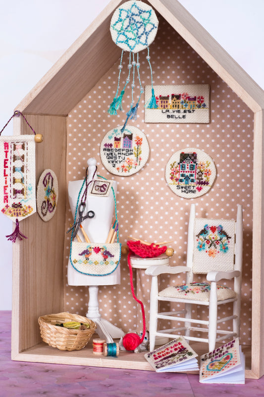 Grille de broderie point de croix : atelier idéal avec mannequin, attrape-rêves, fauteuil et accessoires. Imprimée en couleur avec références DMC sur 8 pages.