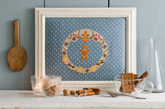 Grille de broderie point de croix « Ronde d’hiver » par Création Point de Croix. Couronne festive aux motifs de badiane, cannelle, orange séchée et pain d’épices. À broder sur lin ou Aïda.