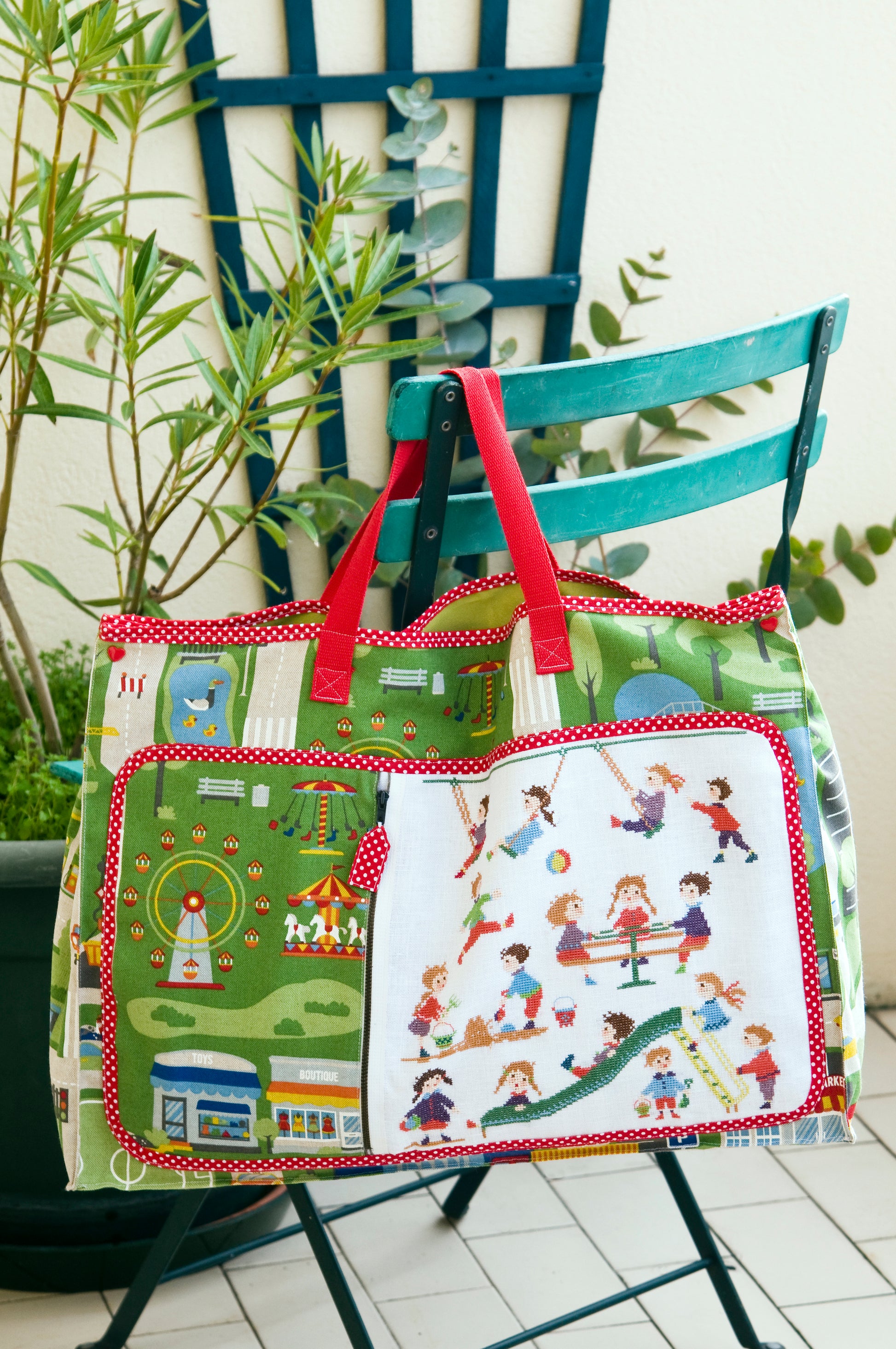 Grille de broderie point de croix : sac à jouets pour aller au parc. Motif 140 x 150 pts, imprimé couleur (Réf. DMC) sur 8 pages. Illustration Perrette Samouiloff