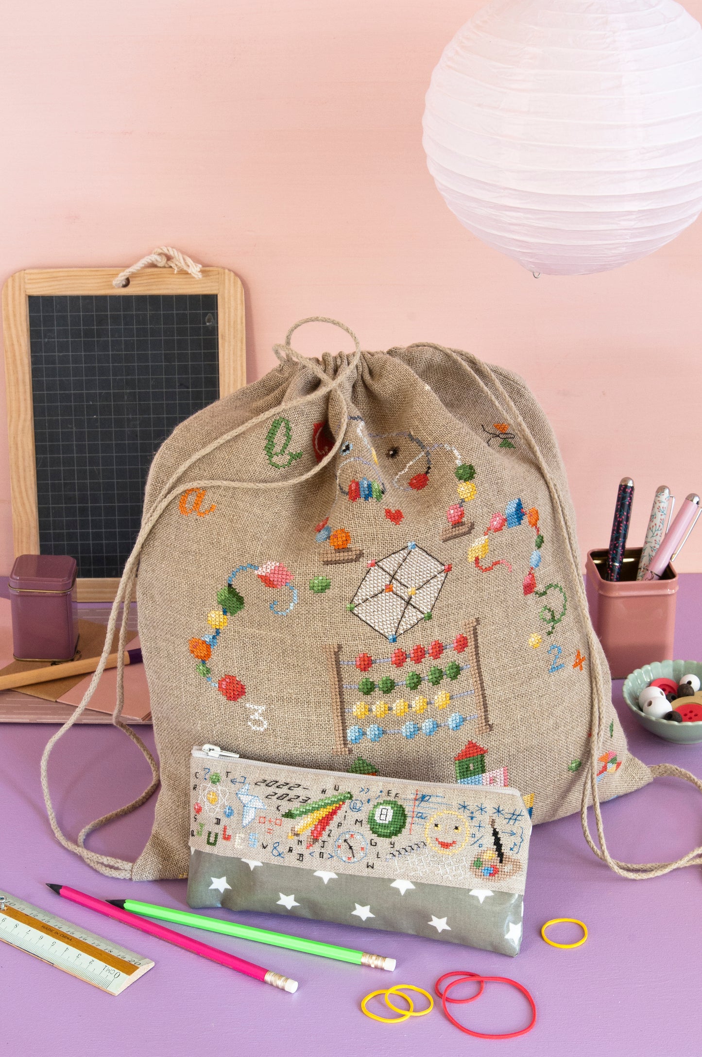 Grille de broderie point de croix « Sac à dos et trousse » par M. Bonnin : accessoires scolaires à broder sur lin bis 11 fils. DMC, 6 pages, sac 27 x 30 cm, trousse 5 x 22 cm.