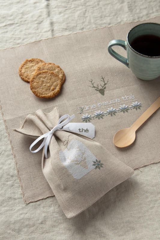 Grille de broderie point de croix « Sachet de thé et set de table » par J. Lentini : flocons de neige sur lin 14 fils. DMC, 6 pages – sachet et set assortis.
