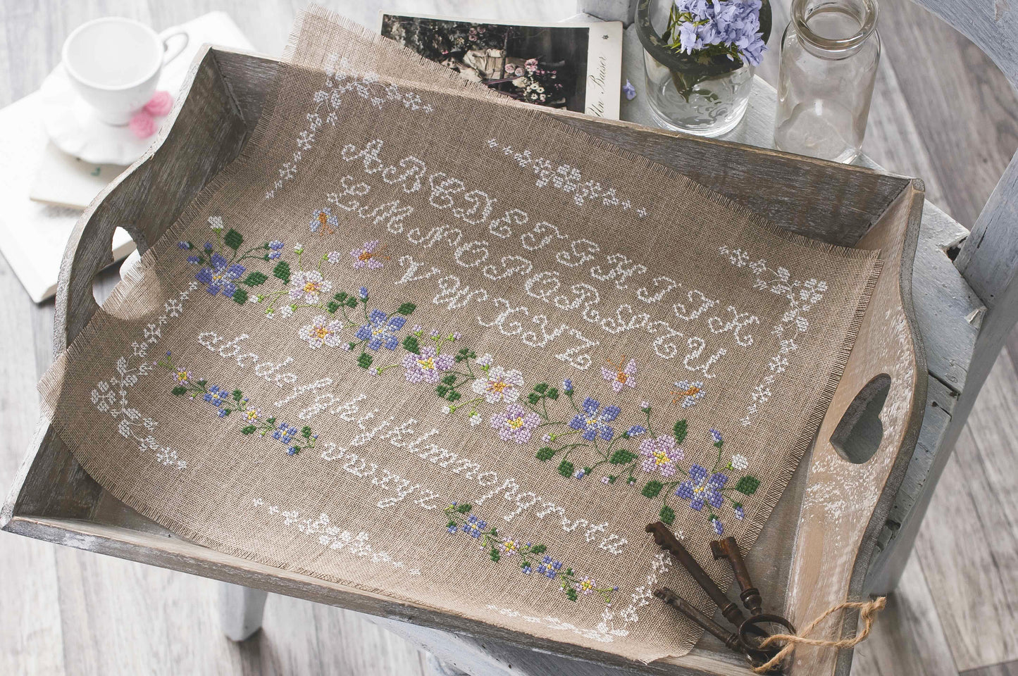 Grille broderie point de croix : sampler fleuri avec alphabet, motif 179×130 pts, 32,5×23,6 cm. Symboles + couleurs DMC, 6 pages.